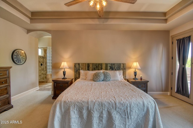 bedroom featuring carpet flooring, arched walkways, baseboards, and ceiling fan