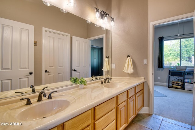 bathroom with a sink, baseboards, tile patterned flooring, and double vanity