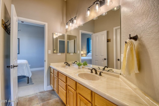 ensuite bathroom featuring double vanity, a sink, ensuite bath, and tile patterned floors