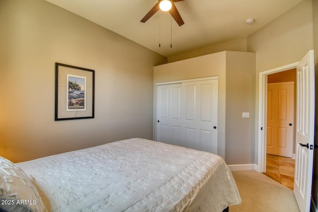 bedroom featuring baseboards, ceiling fan, light carpet, and a closet