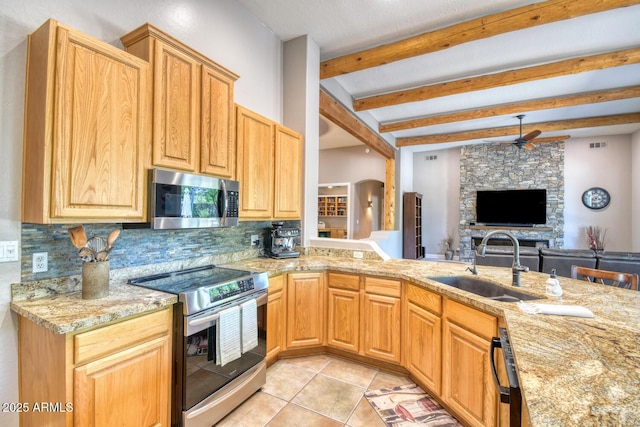 kitchen featuring a sink, stainless steel appliances, a ceiling fan, backsplash, and beamed ceiling