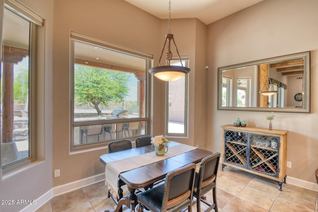 dining area with light tile patterned floors, baseboards, and a healthy amount of sunlight