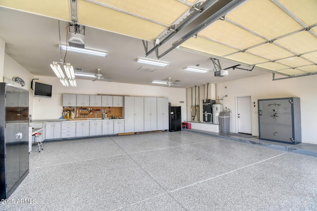 garage with a garage door opener, heating unit, and electric water heater