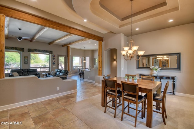 dining room with arched walkways, ceiling fan with notable chandelier, recessed lighting, baseboards, and light tile patterned floors