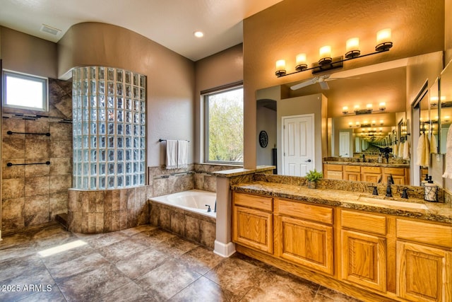 full bath with walk in shower, vanity, a ceiling fan, visible vents, and a bath