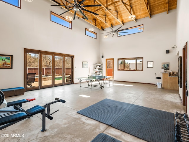 exercise room featuring wood ceiling, a high ceiling, and french doors