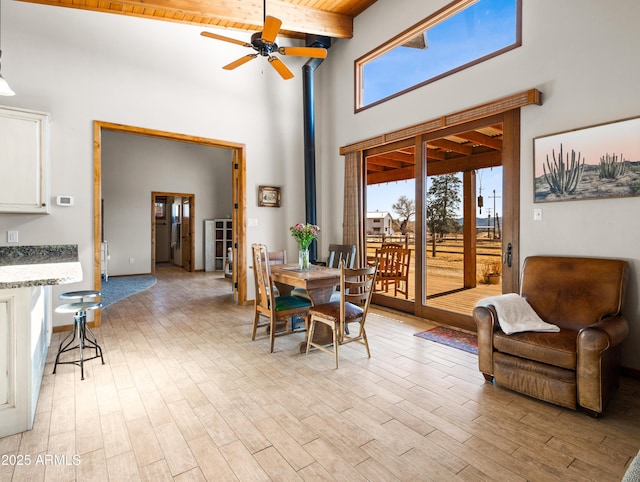 dining room with wood ceiling, beamed ceiling, ceiling fan, and light hardwood / wood-style flooring