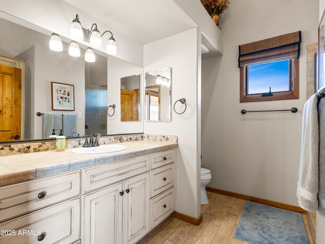 bathroom with toilet, hardwood / wood-style flooring, and vanity