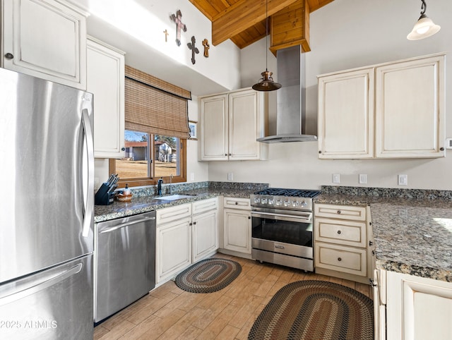 kitchen featuring appliances with stainless steel finishes, wall chimney range hood, pendant lighting, wooden ceiling, and sink