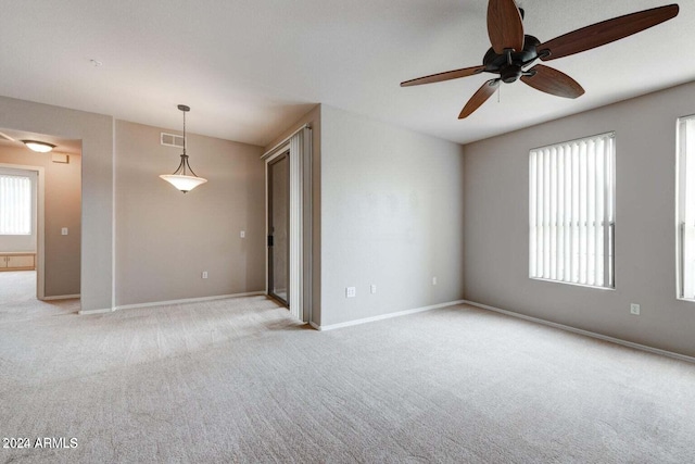 unfurnished room with light carpet, visible vents, and baseboards