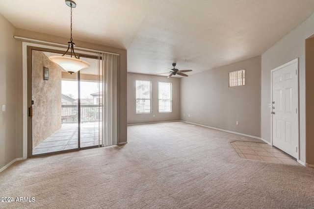 spare room featuring baseboards, a ceiling fan, and light colored carpet