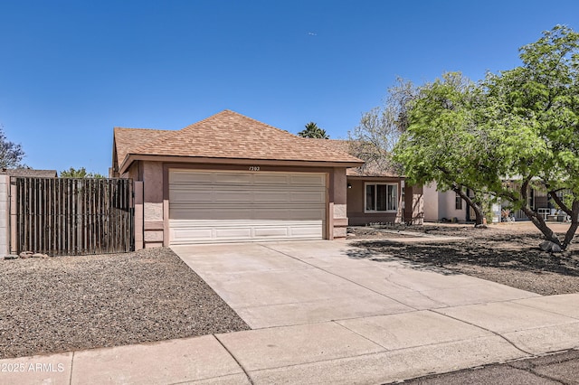 ranch-style house featuring stucco siding, a gate, driveway, and an attached garage