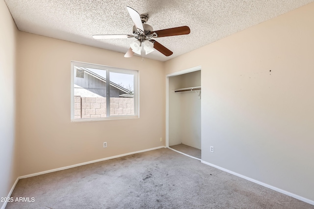 unfurnished bedroom featuring a closet, carpet, baseboards, a ceiling fan, and a textured ceiling