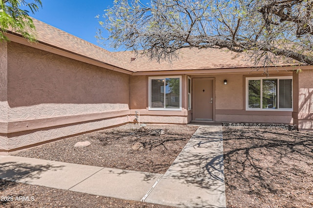 doorway to property featuring stucco siding