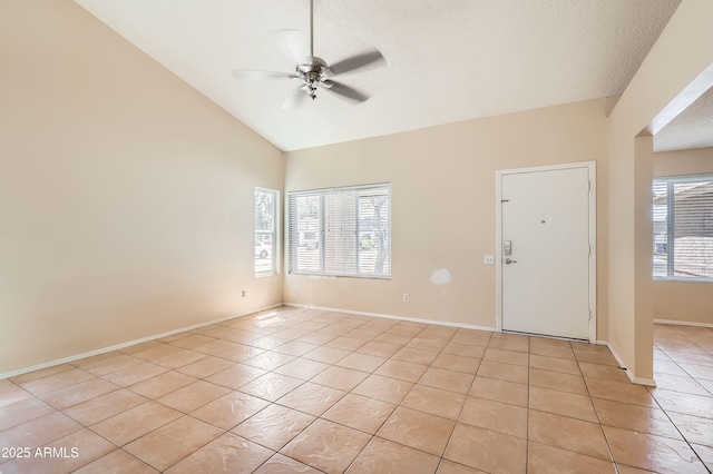 spare room featuring light tile patterned floors, ceiling fan, vaulted ceiling, and a textured ceiling