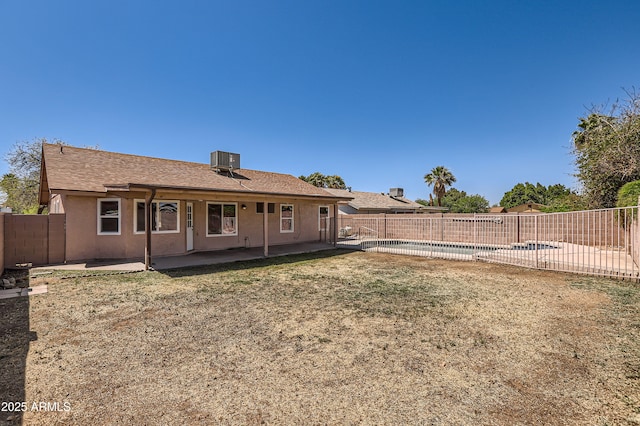back of property with a patio, a fenced in pool, central air condition unit, stucco siding, and a fenced backyard