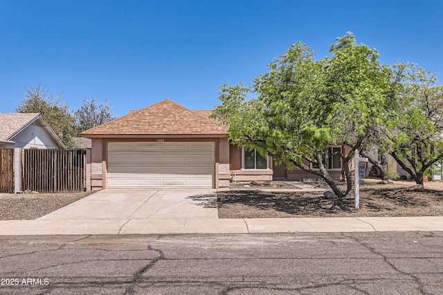 view of front of house with fence, concrete driveway, a shingled roof, an attached garage, and stucco siding