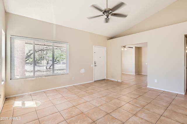 spare room featuring light tile patterned flooring, ceiling fan, lofted ceiling, and baseboards