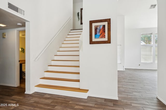 stairs with wood finished floors and baseboards