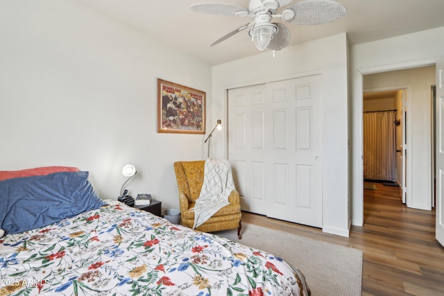 bedroom featuring wood finished floors, ceiling fan, and a closet