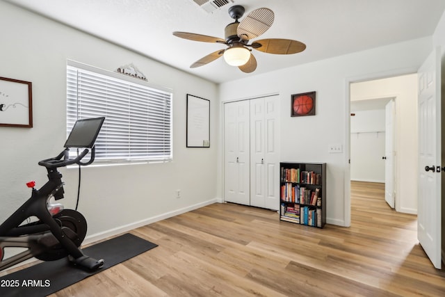 workout room with light wood-style floors, a ceiling fan, and baseboards