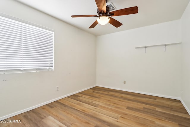 spare room with light wood finished floors, baseboards, and ceiling fan