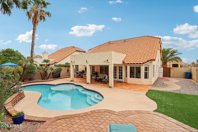view of swimming pool with french doors, a fenced backyard, and a patio area