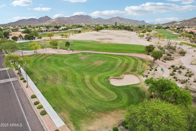 view of property location with mountains, a local golf course, and nearby suburban area