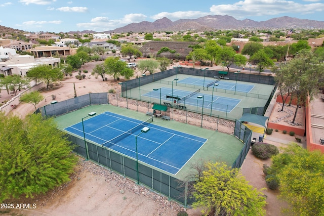view of tennis court featuring fence and a mountain view