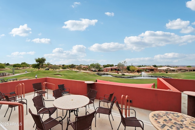 view of patio / terrace featuring golf course view and a water view