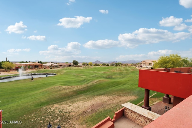 view of property's community featuring golf course view, a lawn, and a water and mountain view