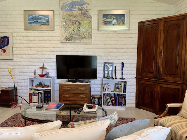 living area featuring brick wall and light wood-style floors