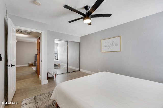 bedroom with light wood-type flooring, a closet, and ceiling fan