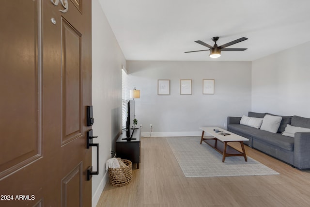 living room with ceiling fan and light hardwood / wood-style flooring