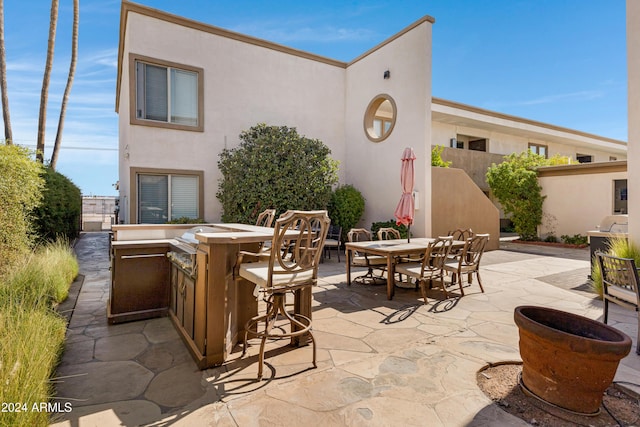 view of patio / terrace with an outdoor kitchen and an outdoor bar