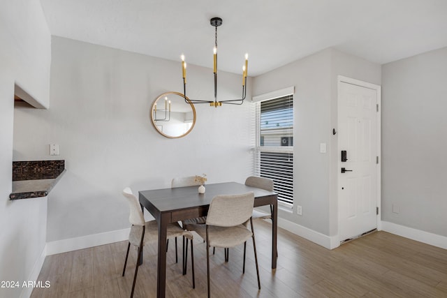 dining space featuring light hardwood / wood-style floors and a notable chandelier