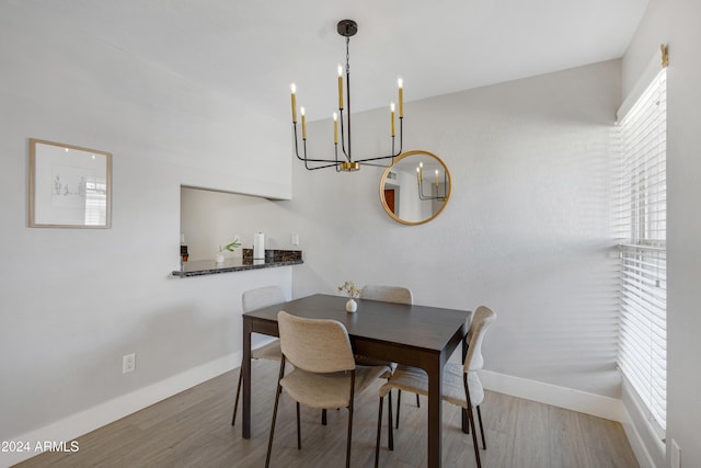 dining space featuring a notable chandelier and light wood-type flooring