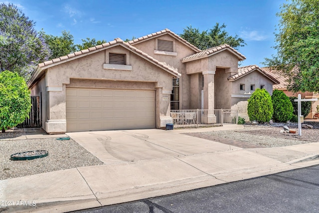 view of front of house with driveway, fence, an attached garage, and stucco siding