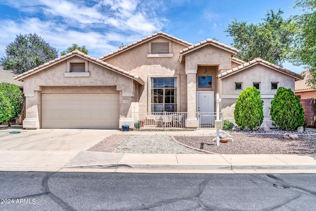 view of front facade with a garage, driveway, and stucco siding