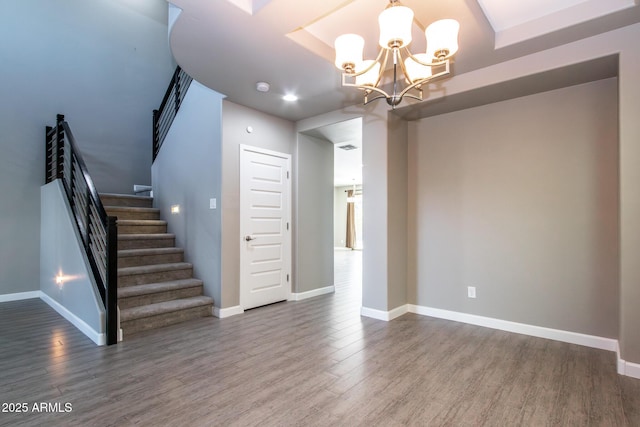 interior space with wood-type flooring and an inviting chandelier