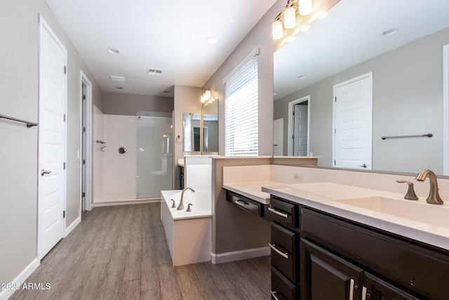 bathroom featuring hardwood / wood-style flooring, vanity, and separate shower and tub