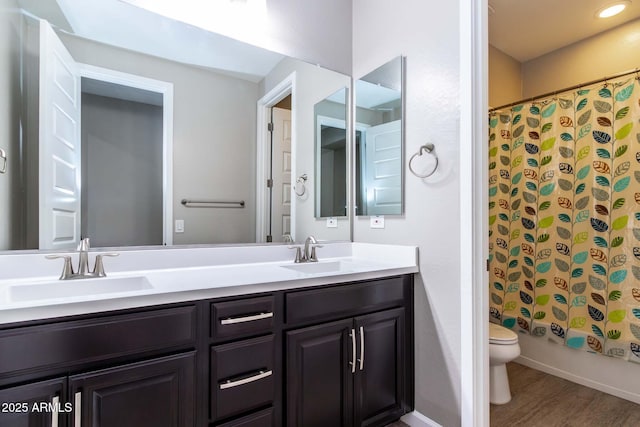 full bathroom with vanity, wood-type flooring, shower / bath combo with shower curtain, and toilet