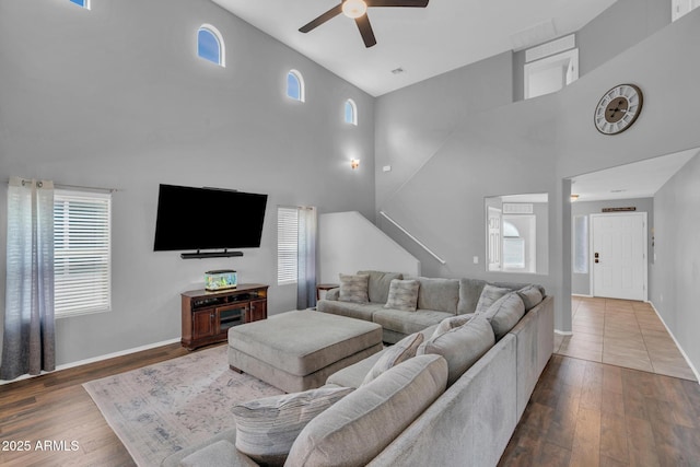 living room with baseboards, ceiling fan, and wood finished floors