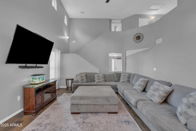 living area featuring dark wood-type flooring, baseboards, visible vents, and ceiling fan