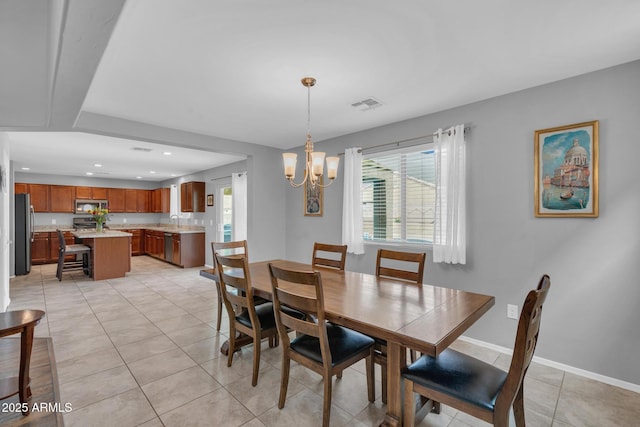 dining room featuring a chandelier, visible vents, baseboards, and light tile patterned flooring