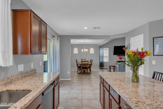 kitchen with light stone counters, visible vents, dishwasher, and light tile patterned flooring