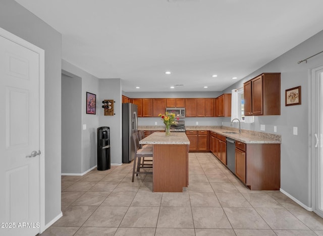 kitchen with a breakfast bar area, a kitchen island, recessed lighting, a sink, and stainless steel appliances