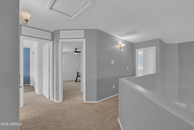 hall featuring an upstairs landing, visible vents, carpet floors, and baseboards