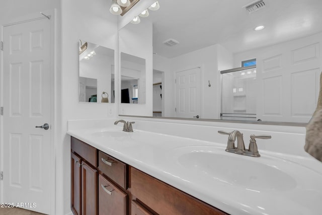 bathroom featuring visible vents, a stall shower, and a sink