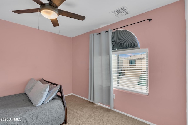 carpeted bedroom with visible vents, a ceiling fan, and baseboards